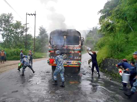Police personnel try to douse the fire after the cadres of Netra Bikram Chand-led CPN Maoist set the truck ablaze, in Tanahun, on Monday, July 25, 2016. Photo: RSS