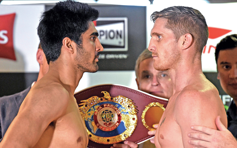 Indiau2019s Vijender Singh (left) and Australiau2019s Kerry Hope pose for photographers after their official weigh-in for the WBO Asia-Pacific Super Middleweight title in New Delhi on Friday.