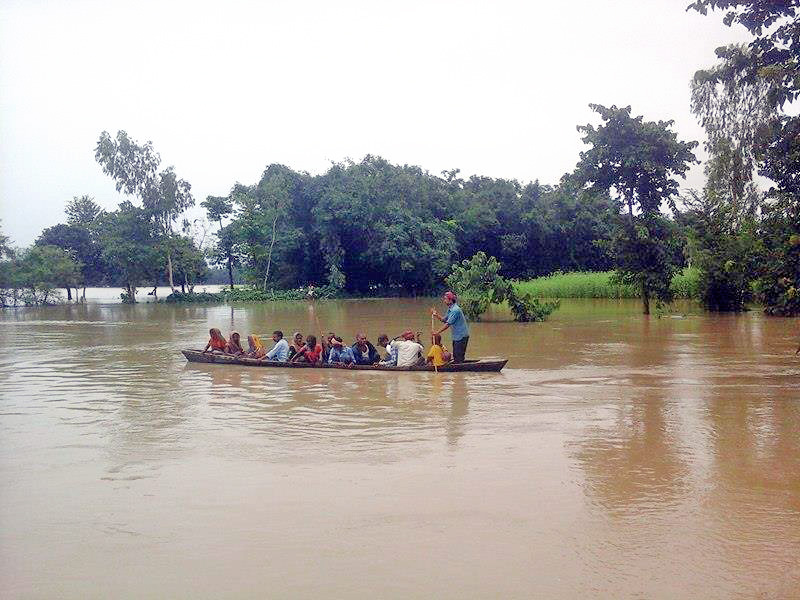 Villagers use a boat to escape to a safer place after their village Koiladi Barhain was inundated, in Saptari district, on Sunday, July 24, 2016. Photo: Byas Shankar Upadhyaya