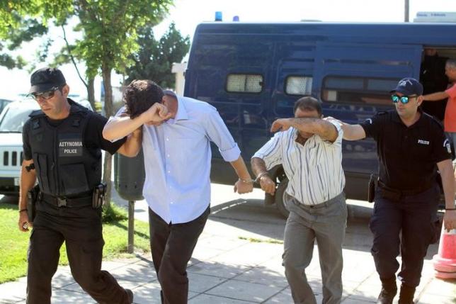 Two of the eight Turkish soldiers who fled to Greece in a helicopter and requested political asylum after a failed military coup against the government, are brought to prosecutor by two policemen in the northern Greek city of Alexandroupolis, Greece, July 17, 2016. REUTERS/Giannis Moisiadis/Intimenews