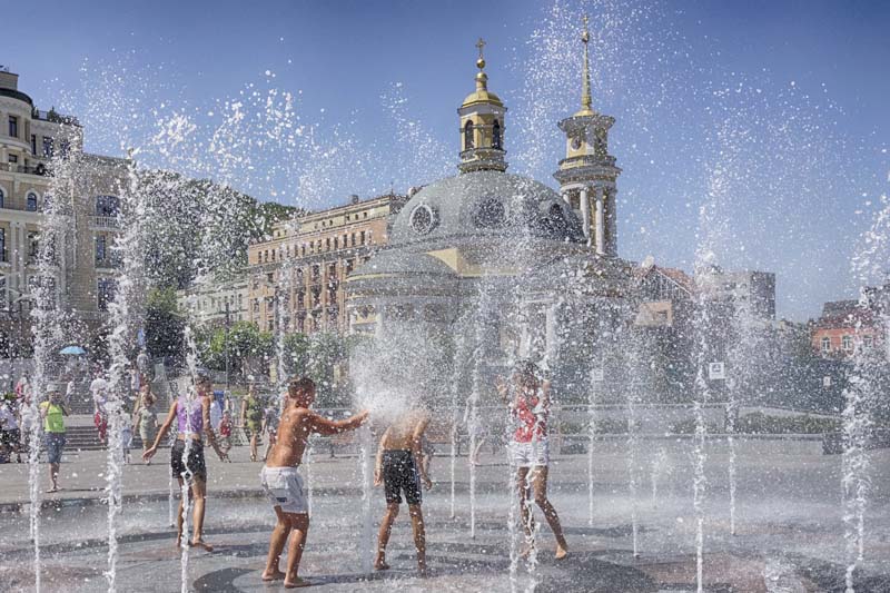 Children enjoy the cool water of a fountain in front of an orthodox Church in Kiev, Ukraine on Wednesday, July 13, 2016. Photo: AP