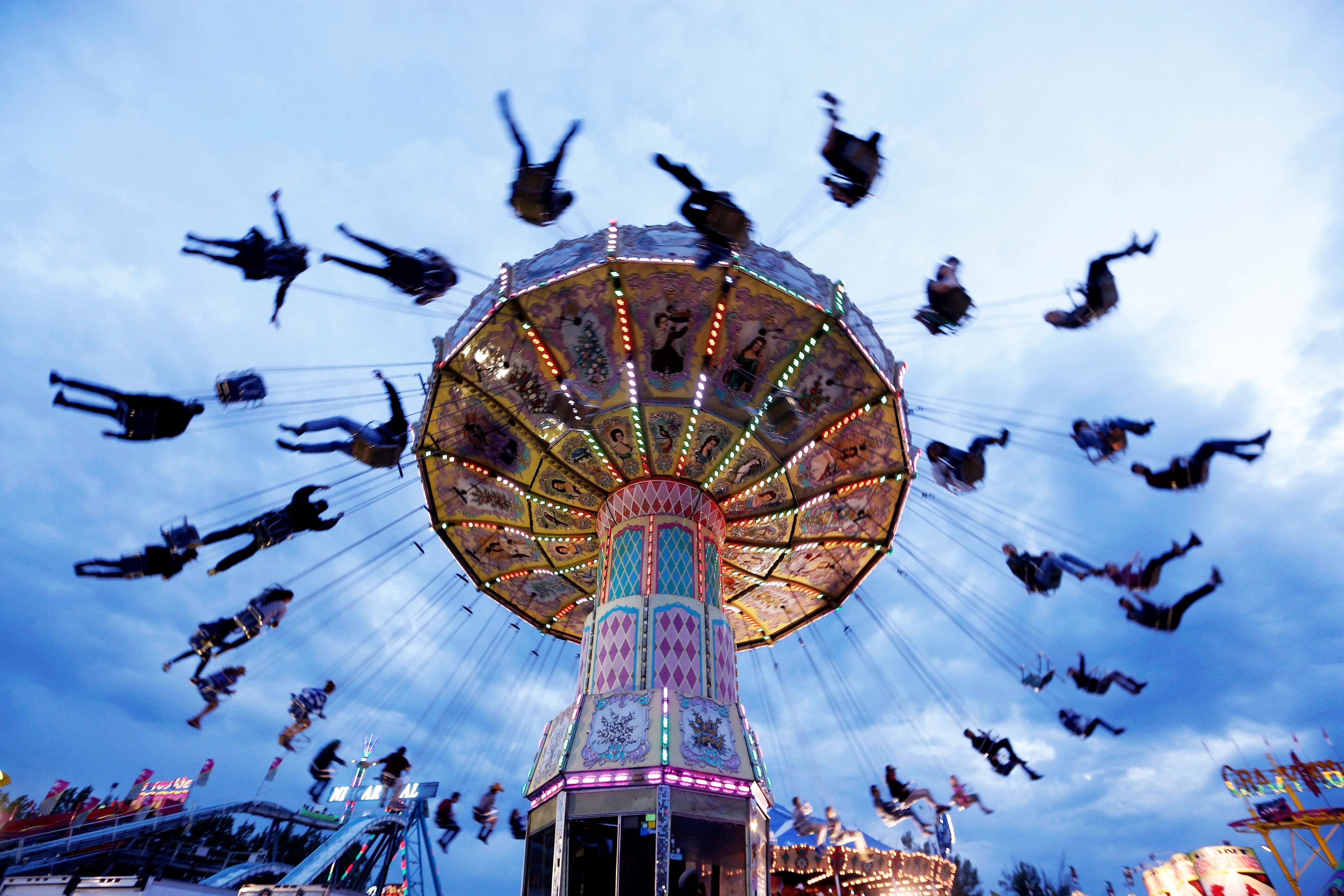 People swing on a ride in the midway during the Calgary Stampede in Calgary, Alberta, Canada on July 14, 2016. Photo: Reuters