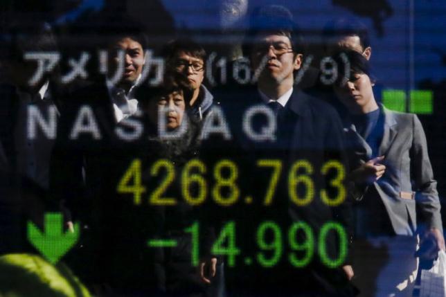 People are reflected in a display showing market indices outside a brokerage in Tokyo, Japan,  February 10, 2016. REUTERS/Thomas Peter