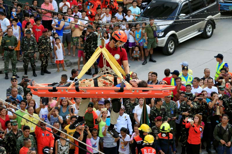 A rescuer rappels from a building while assisting a mock pregnant victim during an earthquake drill as part of the joint capability demonstration of the Philippine Armed Forces' Reserve Command along with other government agencies in observance of national disaster consciousness month in Taguig city, metro Manila, Philippines July 30, 2016. Photo: Reuters