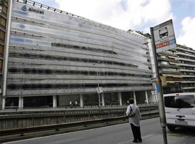 A woman waits for a bus outside Spanish pharmaceutical company Almirall's headquarters in central Barcelona, September 3, 2008. Photo: Reuters