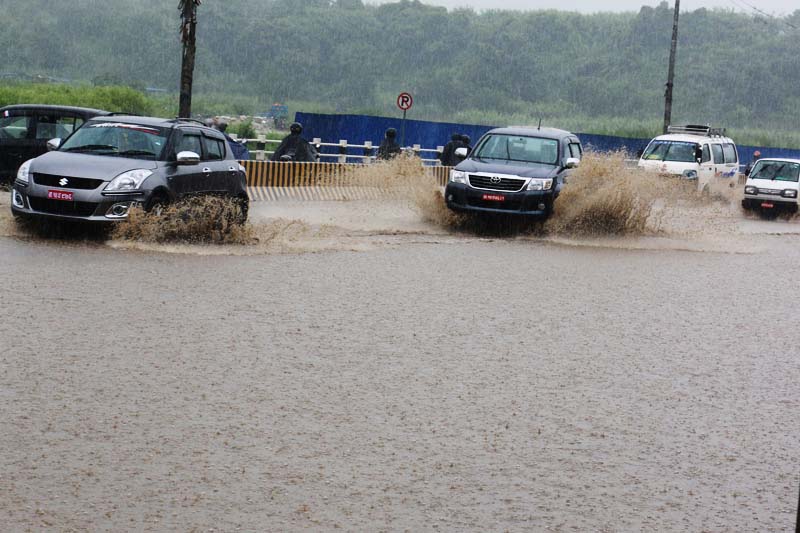 Motorists drive their vehicles along a waterlogged road section in Tinkune of Kathmandu after incessant rainfall, on  Friday, July 22, 2015. Photo: RSS