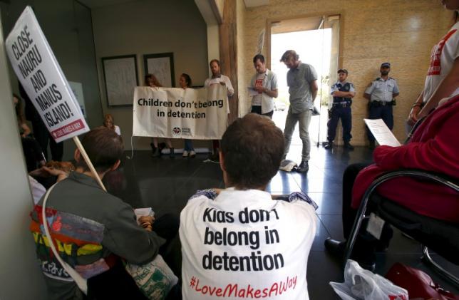 Police watch a group of around twenty protesters occupy Australian Prime Minister Malcolm Turnbull's electoral office, demanding the end to the policy of offshore detention of asylum seekers, in the Sydney suburb of Edgecliff, Australia, October 14, 2015.  REUTERS/David Gray