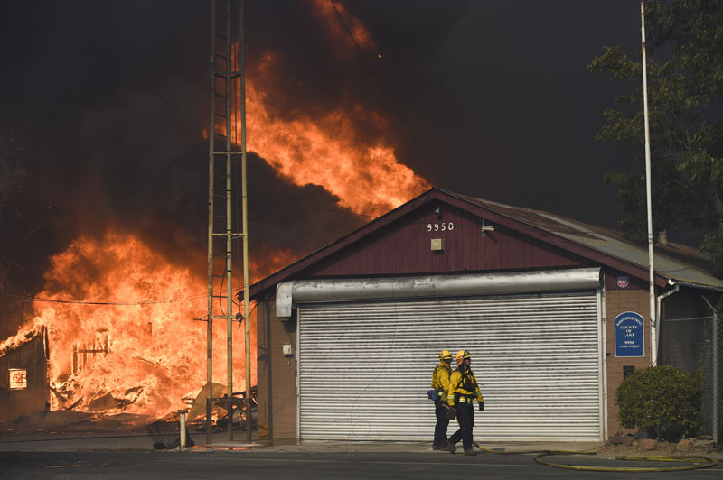 Multi agency fire crews battle a wildfire as structures catch on fire in Lower Lake, California, on Sunday, Aug. 14, 2016. Photo: Hector Amezcua/The Sacramento Bee via AP