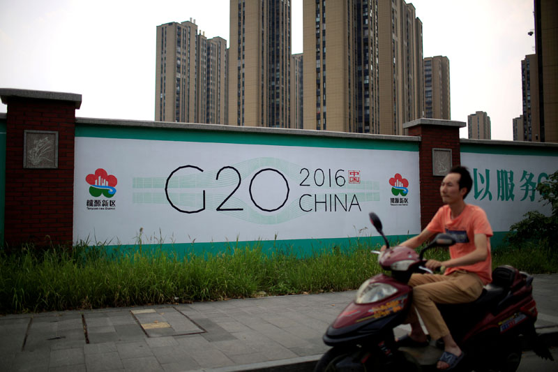 A man rides an electronic bike past a billboard for the upcoming G20 summit in Hangzhou, Zhejiang province, China, on July 29, 2016. Photo: Reuters