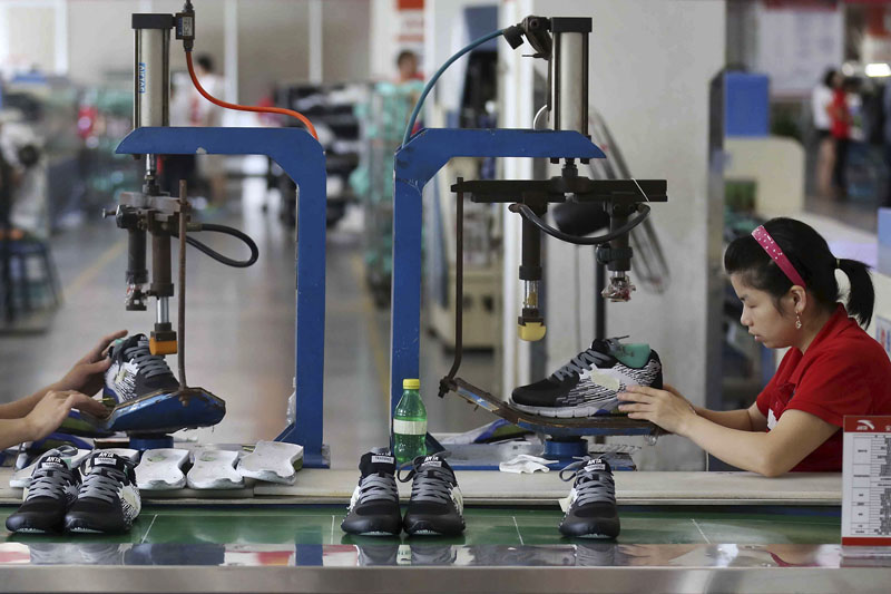 Workers assemble sneaker at a factory in Jinjiang city in southeast China's Fujian province, on Wednesday, July 27, 2016. Photo: Chinatopix Via AP