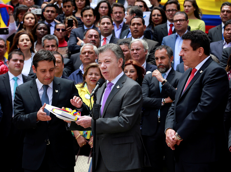 Colombia's President Juan Manuel Santos (C) presents the FARC peace accord to the president of the Colombian congress Mauricio Lizcano (L) in Bogota, Colombia, August 25, 2016. Photo: Reuters