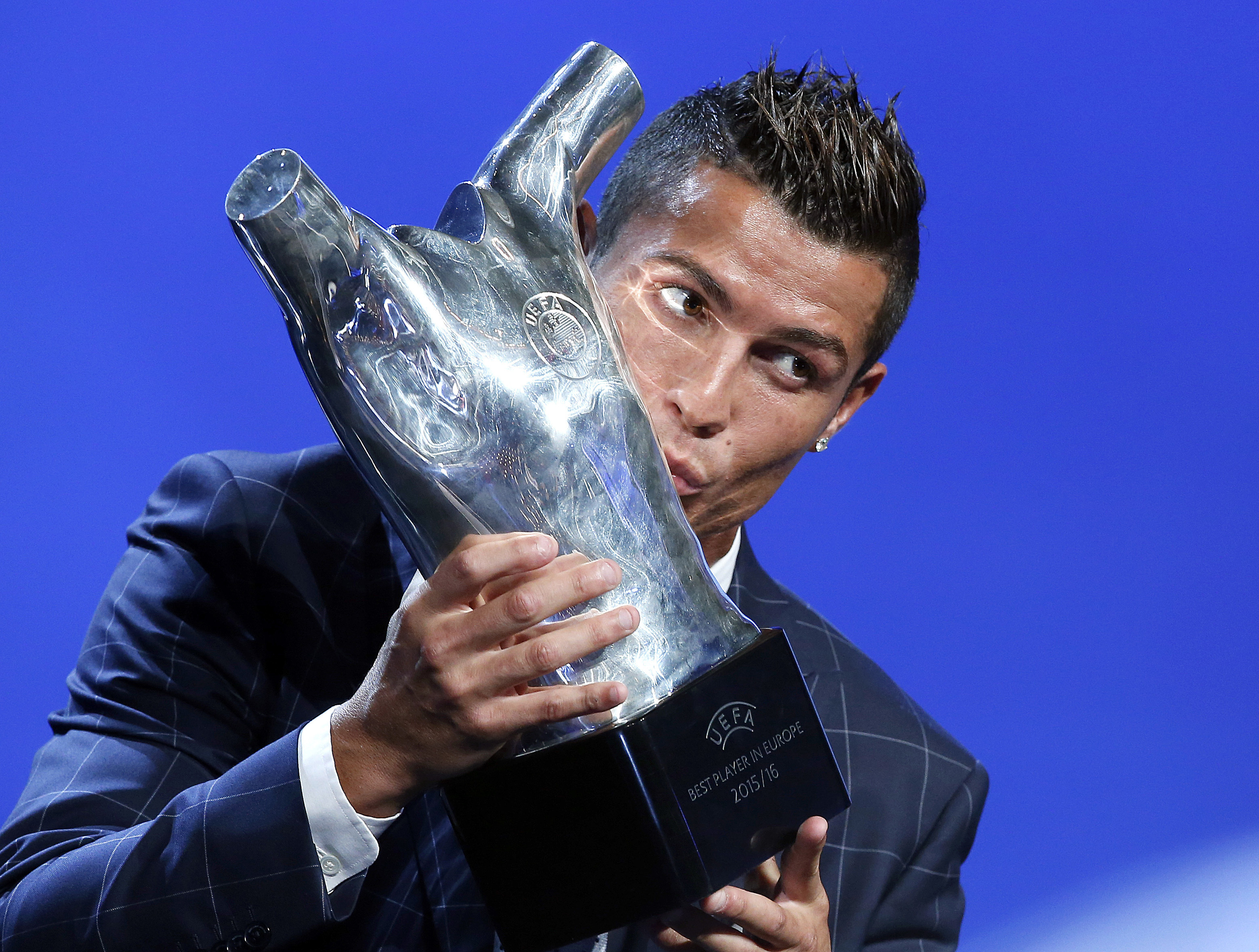 Real Madrid's forward Cristiano Ronaldo of Portugal, kisses his trophy after winning the best player of the year award, during the UEFA Champions League draw, at the Grimaldi Forum, in Monaco, Thursday, August 25, 2016. Photo: AP