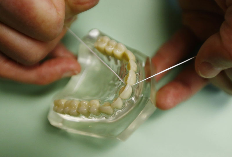 Dr Wayne Aldredge, president of the American Academy of Periodontology, demonstrates how dental floss should be used in Holmdel, New Jersey. Photo: AP