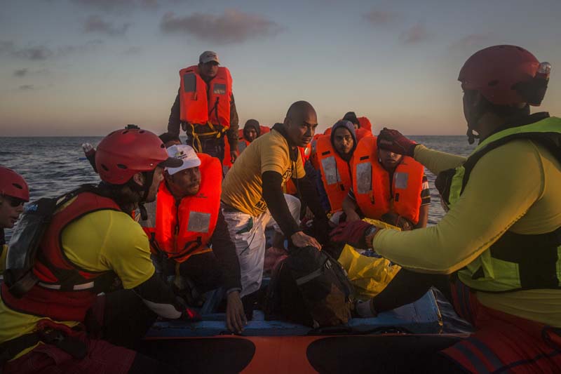 File- Refugees and migrants overcrowd a wood boat as they are rescued by a team of the Spanish NGO Proactiva Open Arms during a rescue operation on the Mediterranean sea, about 19 miles north of Az Zawiyah, Libya, on Thursday, July 21, 2016. Photo: AP