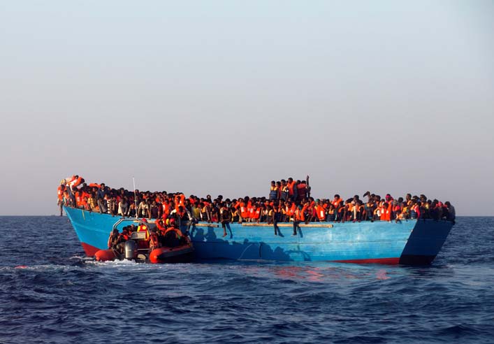 A rescue boat of the Spanish NGO Proactiva approaches an overcrowded wooden vessel with migrants from Eritrea, off the Libyan coast in Mediterranean Sea on Monday, August 29, 2016. Photo: Reuters