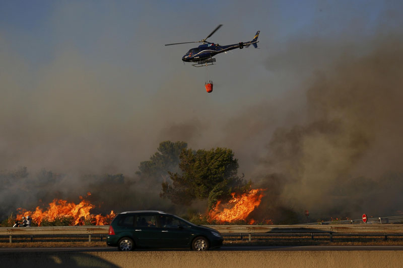 Flames and smoke are seen during fires which burn north of Marseille, France, August 10, 2016. Photo: REUTERS