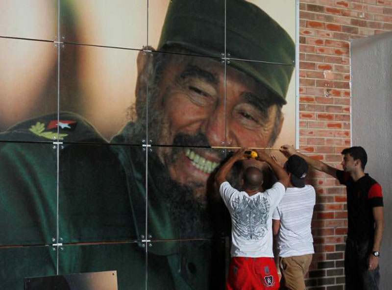 Workers install a photograph of Cuba's former president Fidel Castro at the Expocuba exhibition center in preparation for his upcoming 90th birthday in Havana, Cuba, on August 12, 2016. Photo: Reuters