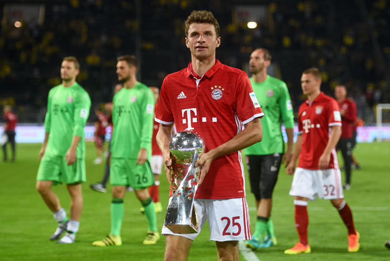 Munich's soccer player Thomas Mueller  poses with the trophy  after the German Super Cup match between Borussia Dortmund and Bayern Munich in Dortmund, Germany, on Sunday, August 14, 2016. Munich won by 2-0.  Photo: Jonas Guettler/dpa via AP