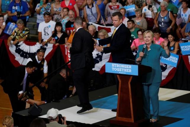 U.S. Democratic presidential nominee Hillary Clinton speaks as secret service officers work to control a protestor during a rally at Lincoln High School in Des Moines, Iowa August 10, 2016. REUTERS/Chris Keane