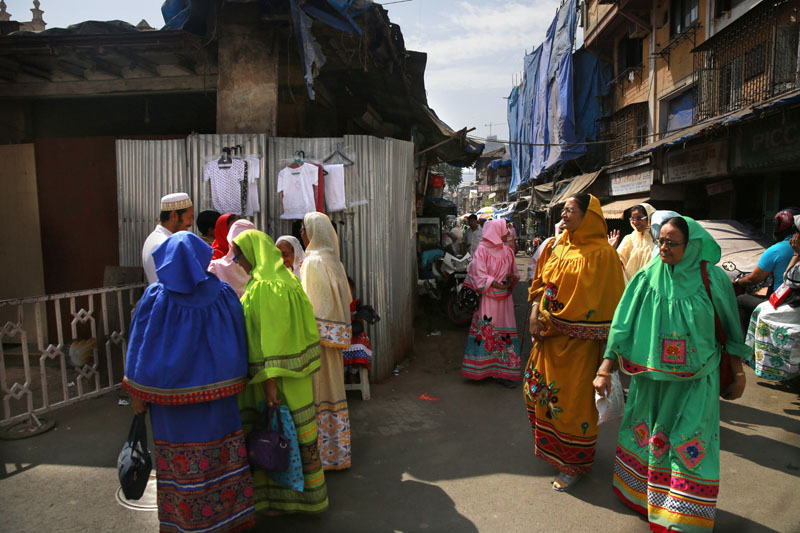 Indian Dawoodi Bohra women walk past others shopping for clothes in a Bohra neighborhood in Mumbai, India, on February 21, 2016. Photo: AP
