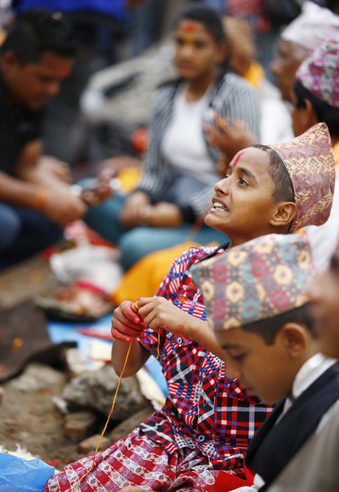 A young hindu priest holds a colorful thread (Raksha Bandhan) on the occasion of Janai Purnima in the Pashupatinath Area on Thursday, August 18, 2016. Photo: Rajesh Gurung
