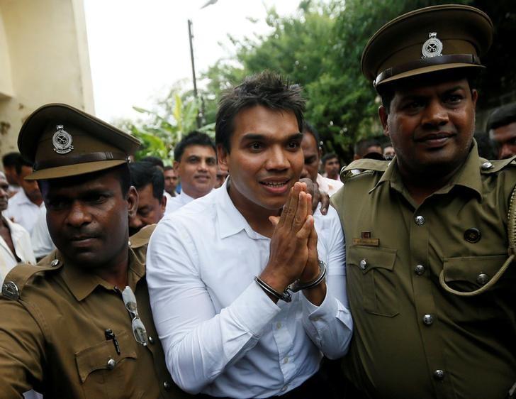 FILE PHOTO: Namal Rajapaksa (C), son of former Sri Lanka's President Mahinda Rajapaksa, leaves with prison officers at court after being arrested in Colombo, Sri Lanka July 11, 2016. REUTERS/Dinuka Liyanawatte/File photo