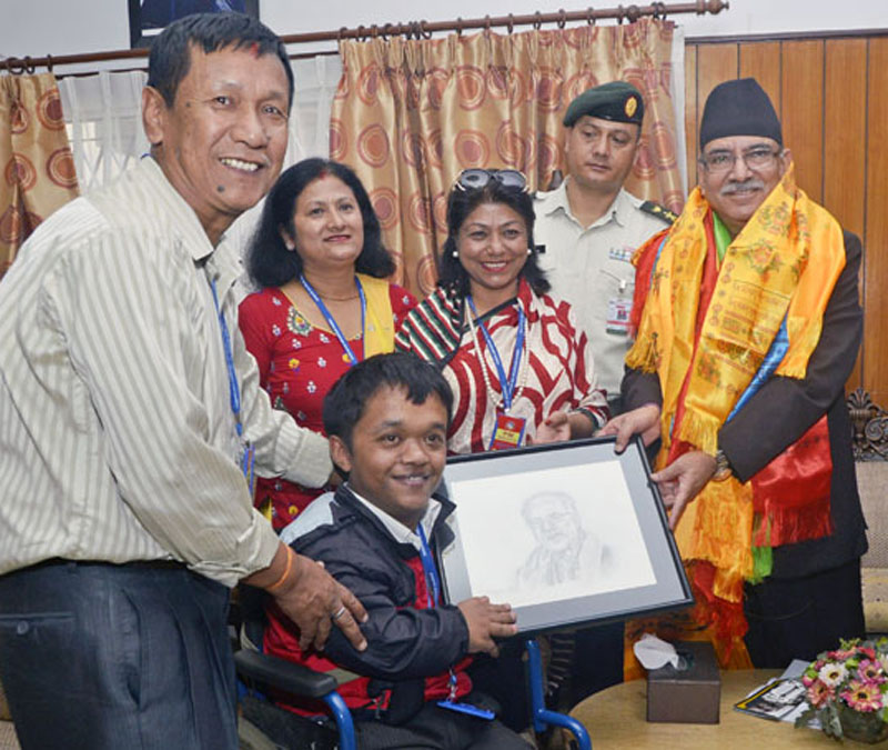 Prime Minister Pushpa Kamal Dahal receives his portrait from a differently-abled Ramesh Barahi when a delegation of civil society members from Lalitpur went to meet him at the PM's official residence in Kathmandu, on Tuesday, August 23, 2016. Photo: PM's Secretariat
