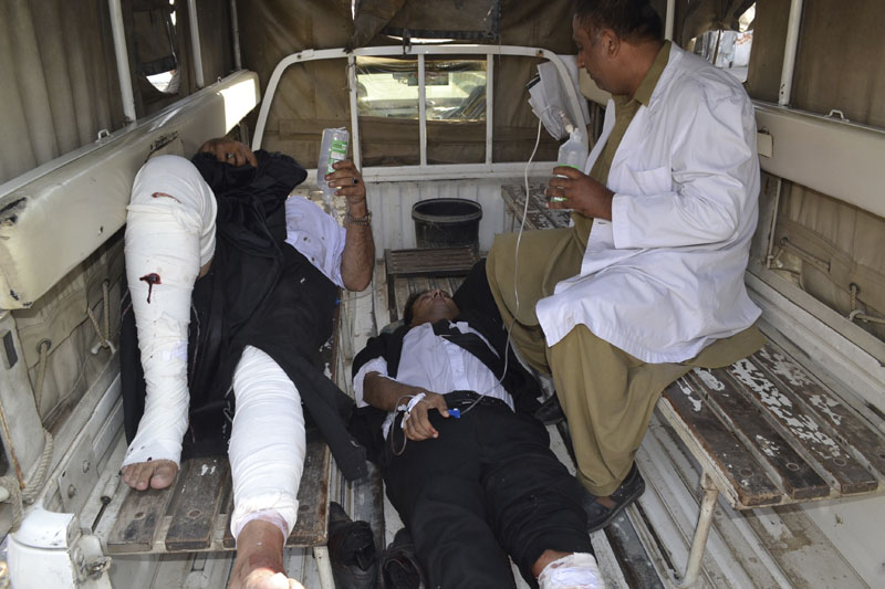 A Pakistani paramedic carries accompany injured lawyers to a hospital following a bomb blast in Quetta, Pakistan, on Monday, August 8, 2016. A powerful bomb went off on the grounds of a government-run hospital Monday, killing dozens of people, police said. Photo: AP
