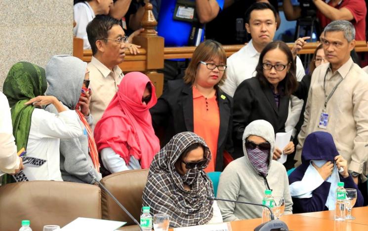 Relatives of slain people cover their faces as they attend a Senate hearing investigating drug-related killings at the Senate headquarters in Pasay city, metro Manila, Philippines August 22, 2016. REUTERS/Romeo Ranoco