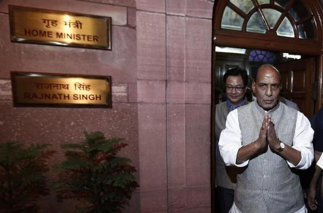 India's Home Minister Rajnath Singh (R) greets the media as he leaves his office after taking charge inside the home ministry in New Delhi May 29, 2014. On the left is Minister of State for Home Affairs Kiren Rijiju. REUTERS/Adnan Abidi/Files