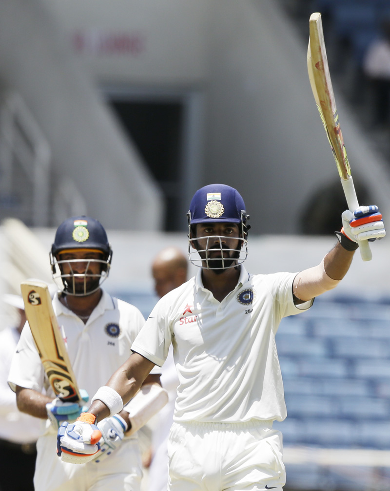 India's Lokesh Rahul celebrates after he scored a century during his partnership with India's Cheteshwar Pujara, back left, during day two of their second cricket Test match against West Indies at the Sabina Park Cricket Ground in Kingston, Jamaica, Sunday, July 31, 2016. Photo: AP