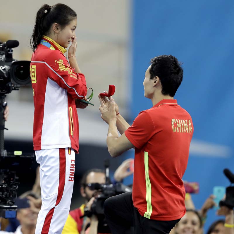 China's silver medalist He Zi (left) receivers a marriage proposal by China's diver Qin Ki (right) during the medal ceremony for the the women's 3-meter springboard diving final in the Maria Lenk Aquatic Centre at the Rio Olympics 2016 in Rio de Janeiro, Brazil, on Sunday, August 14, 2016. Photo: AP