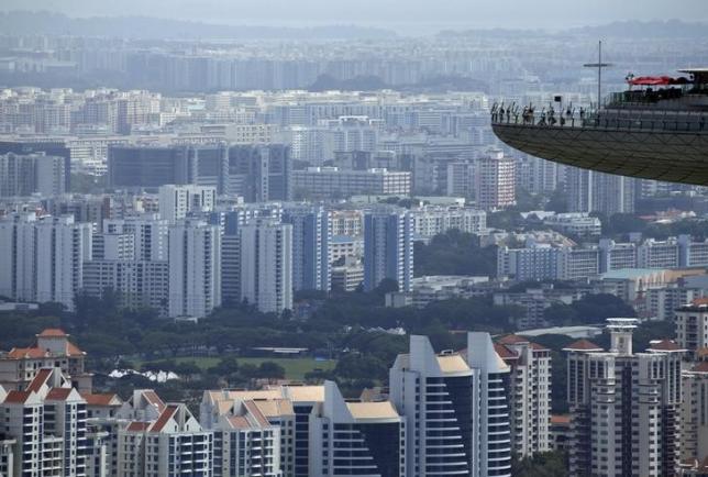 People look out from the observation tower of the Marina Bay Sands amongst public and private residential apartment buildings in Singapore, February 22, 2016. REUTERS/Edgar Su/File Photo