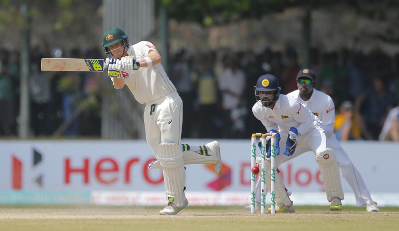 Australia's Steve Smith plays a shot as Sri Lanka's wicketkeeper Dinesh Chandimal and Angelo Mathews watch on the day three of their second test cricket match in Galle, Sri Lanka, Saturday, August 6, 2016. Photo: AP