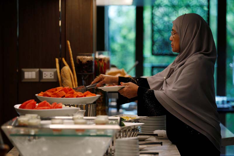 A Muslim visitor takes food from a platter for her breakfast at the Al Meroz hotel in Bangkok, Thailand, on Monday, August 29, 2016. Photo: Reuters