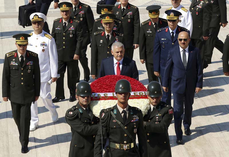 Turkey's Prime Minister Binali Yildirim (Centre),escorted by the country's top generals, attends a wreath-laying ceremony at the mausoleum of modern Turkey's founder Mustafa Kemal Ataturk, ahead of a High Military Council meeting in Ankara, Turkey, on Thursday, July 28, 2016. Photo: AP