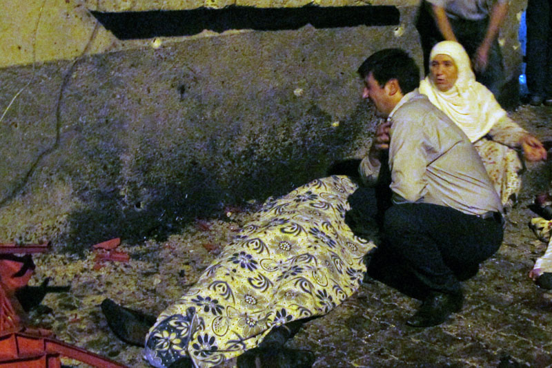 A man and a woman mourn next to a body of one the victims of a blast targeting a wedding ceremony in the southern Turkish city of Gaziantep, Turkey, on August 20, 2016. Photo: Ihlas News Agency via Reuters