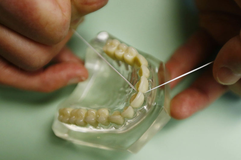 Dr. Wayne Aldredge, president of the American Academy of Periodontology, demonstrates how dental floss should be used in Holmdel, New Jersey. Photo: AP