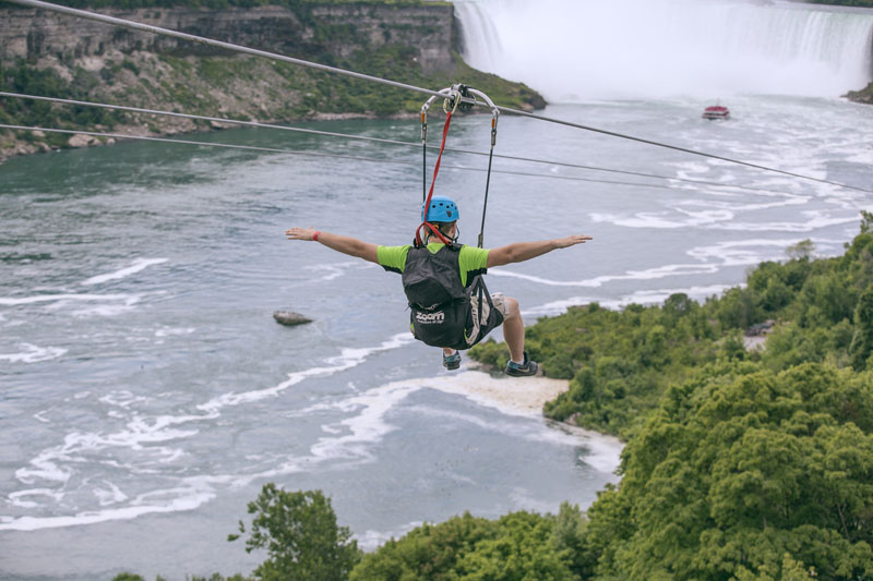 A tourist suspended above the water from zip lines makes his way at speeds of up to 40 mph toward the the mist of the Horseshoe Falls, on the Ontario side of Niagara Falls, on July 19, 2016. Photo: Kien Tran/WildPlay Ltd via AP