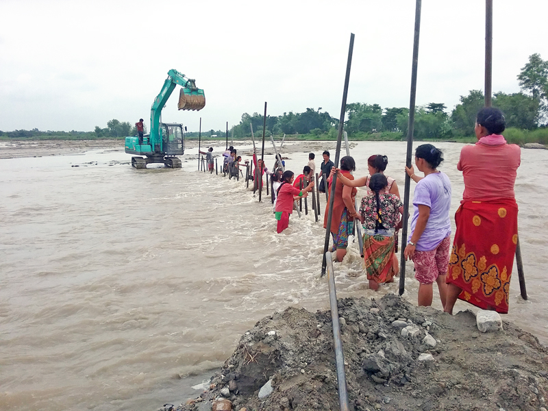 Locals of Shaniarjun Municipality-3 in Jhapa district constructing an embankment to change the course of the Biring River in the area, on Monday, August 1, 2016. Photo: RSS
