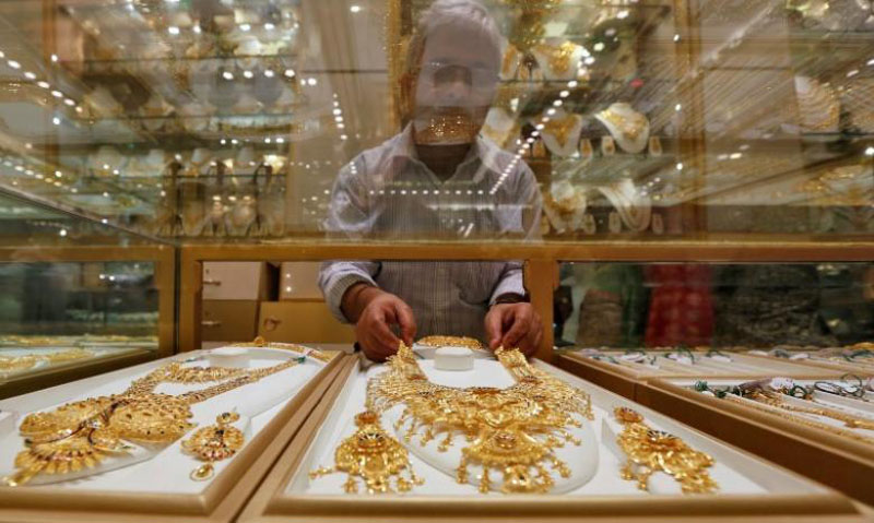 A salesman arranges a gold necklace in a display case inside a jewellery showroom on the occasion of Akshaya Tritiya, a major gold buying festival, in Kolkata, India, on May 9, 2016. Photo: Reuters