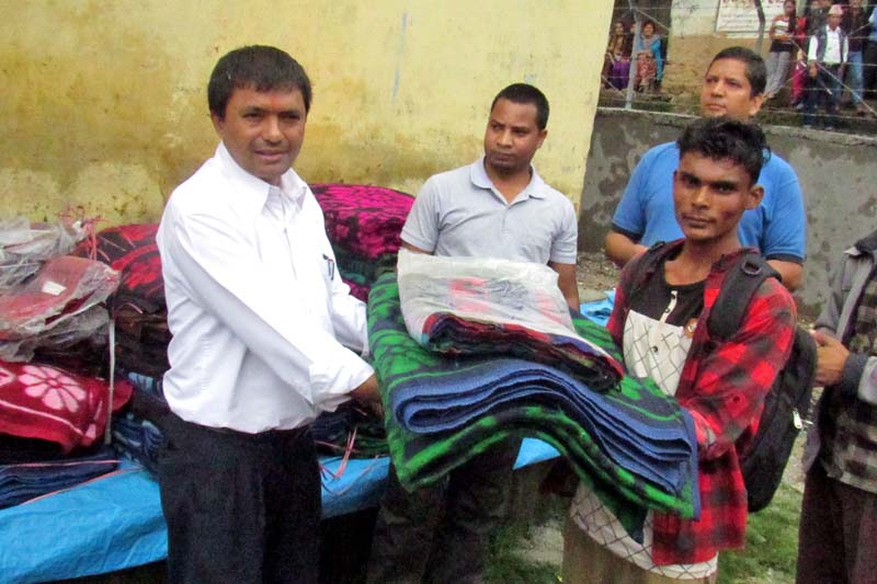 Caritas Nepal Mid- and Far-Western Regional Coordinator Janak Sharma distributes relief materials to flood victims in Bajura district, on Monday, August 01, 2016. Photo: Prakash Singh/ THT