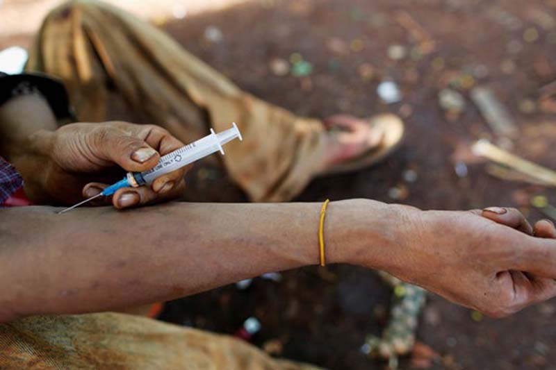 A man injects heroin into his arm along a street in Man Sam, northern Shan state, Myanmar on July 11, 2016. Photo: Reuters
