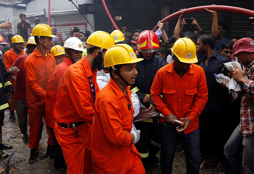 Rescue team members remove a dead body at a food and cigarette packaging factory after a fire broke out outside of Dhaka, Bangladesh, September 10, 2016. REUTERS/Mohammad Ponir Hossain