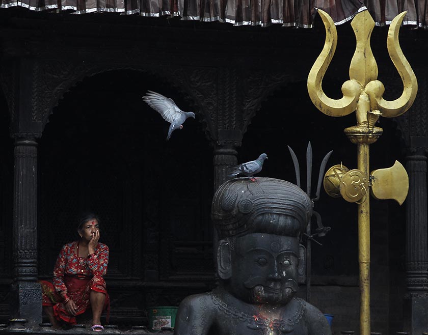 Pigeons land on a statue as a Nepali woman takes rest at the Dattatreya Temple in Bhaktapur, Nepal, Monday, Sept. 12, 2016. Bhaktapur, also known as the city of devotees, is an ancient city popular for its traditional architectural buildings, temples and unique festivals. Photo: AP