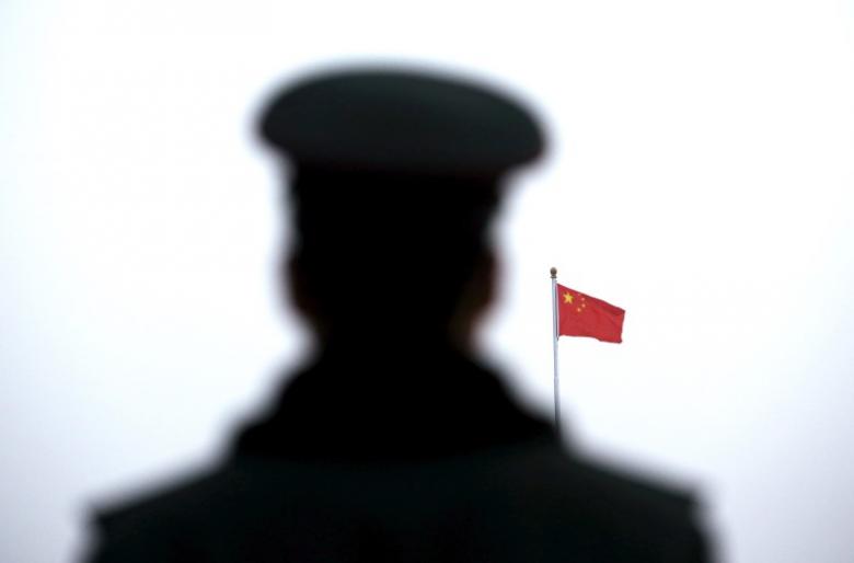 A paramilitary policeman watches a flag-raising ceremony at Tiananmen Square ahead of the opening session of the National People's Congress (NPC) in Beijing, China, March 5, 2016. REUTERS/Kim Kyung-hoon