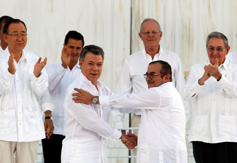 Colombian President Juan Manuel Santos (L) and Marxist rebel leader Rodrigo Londono (R), better known by the nom de guerre Timochenko, shake hands after signing an accord ending a half-century war that killed a quarter of a million people in Cartagena, Colombia September 26, 2016. Photo: Reuters