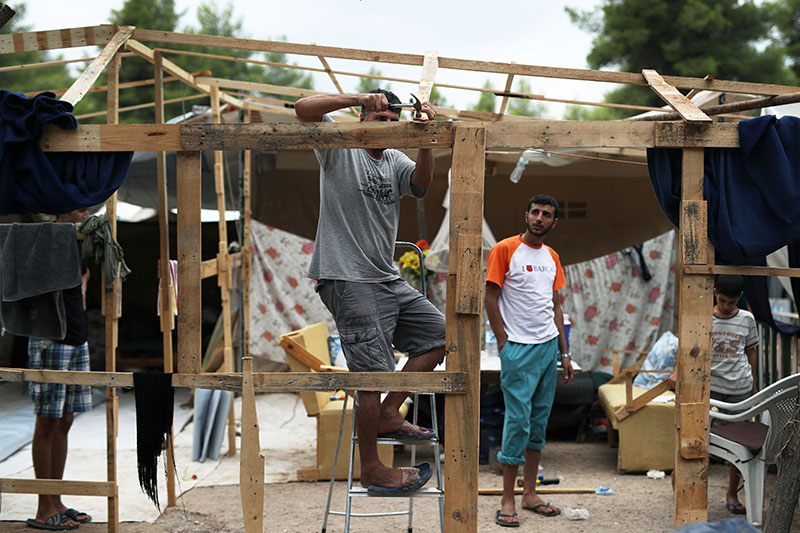 A Syrian man hammers a nail on woods as he prepares his family tent for winter at Ritsona refugee camp north of Athens, which hosts about 600 refugees and migrants on Thursday, September 8, 2016. Photo: AP