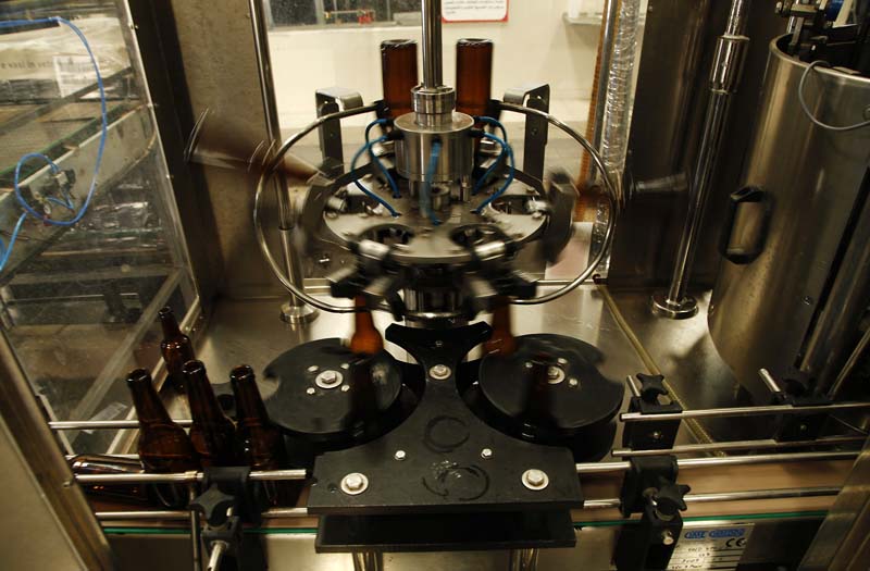 File- A machine lifts, spins and cleans bottles at the start of the Carakale Brewery's assembly line in Fuheis, Jordan, on September 6, 2016. Photo: AP