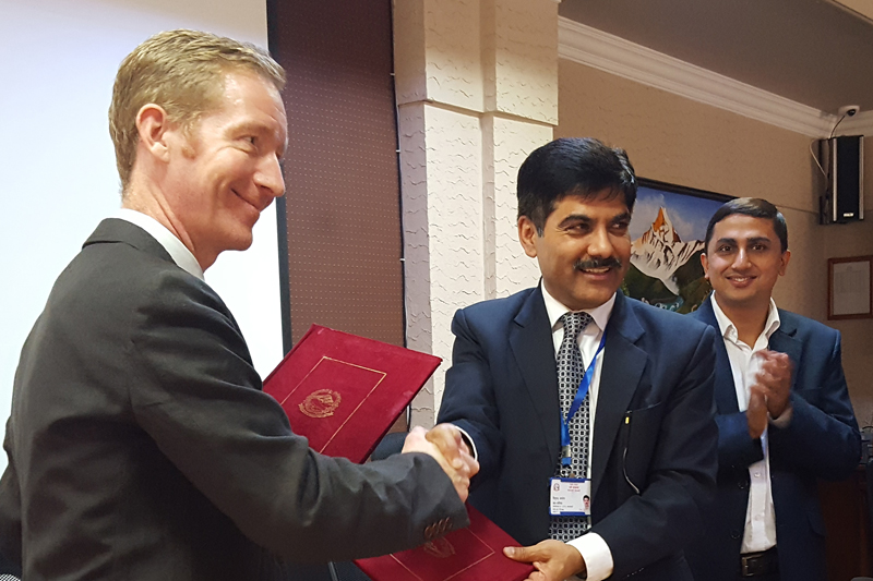 Chief of International Economic Cooperation Coordination Division and Joint Secretary at the Ministry of Finance Ministry, Baikuntha Aryal (centre), and Deputy Head of UK Department of International Development (DFID)-Nepal, Mark Smith exchange a memorandum of understanding about the UK assistance to implement the National Health Sector Strategy, in Kathmandu, on Wednesday, September 14, 2016. Photo: British Embassy